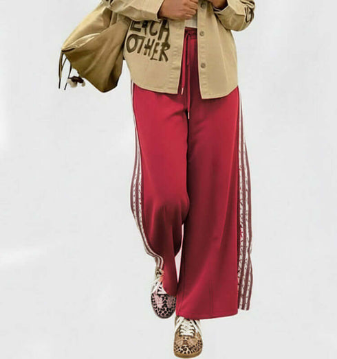 טרנינג בגוון אדום עמוק עם פסי תחרה לבנים ורוכסן, מושלם למראה ספורטיבי ואלגנטי.