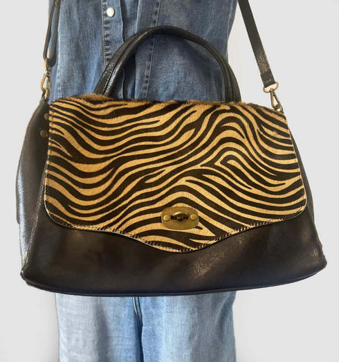 Italian leather and fur handbag in leopard and black with copper accents, stylish shoulder strap, and chic design.