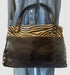 Stylish Italian leather handbag in black with leopard print and copper accents, perfect for any outfit.