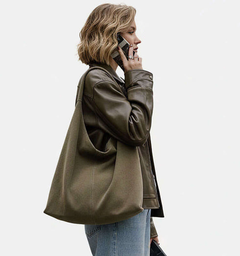 תיק עור ז'אמש מובחר בגוון ירוק חאקי תלוי על הכתף, אופנתי ואיכותי.