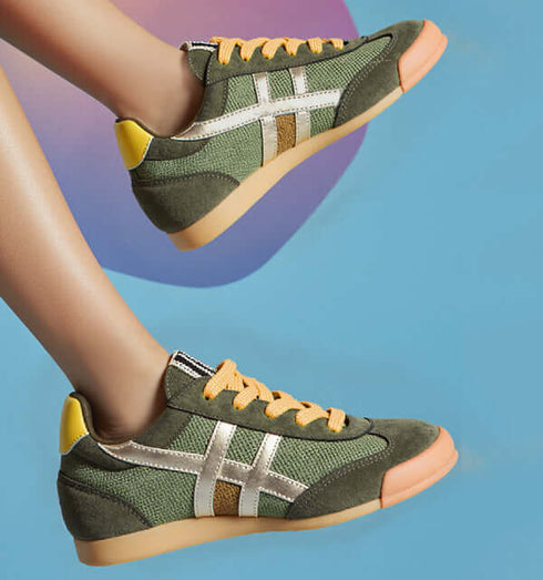 Stylish summer sneakers in green with gold emblem and orange laces against a blue background.