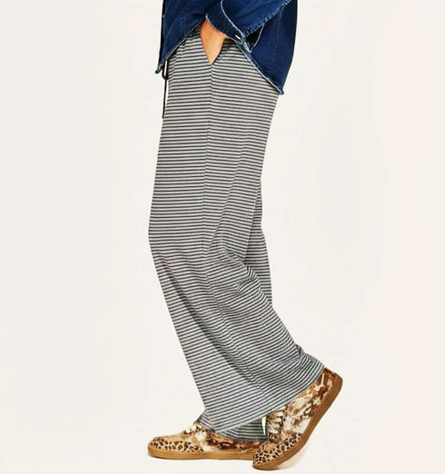 מכנסי כותנה קלילים בגוון אפור עם פסים, גומי במותניים וכיסים, בשימוש יומיומי.