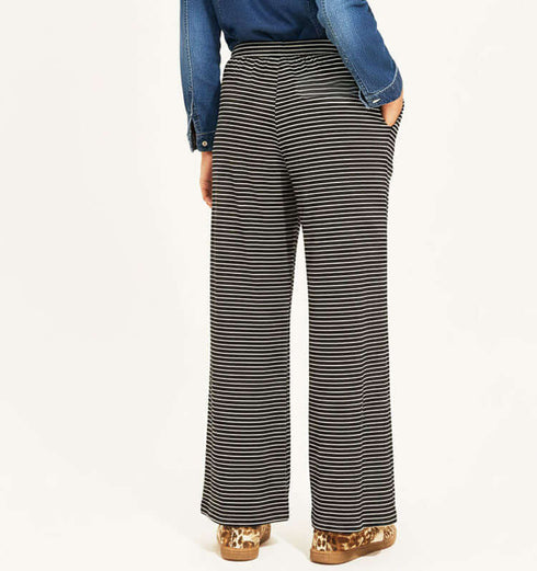 מכנסי כותנה בגוון שחור עם פסים, גומי במותניים וכיסים מתוך צילום אחורי.