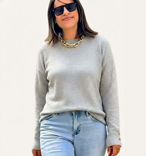 סריג דק במרקם קטיפתי בגוון אפור בהיר, מציג אישה בחולצת סריג דק עם ג'ינס ותכשיטים.