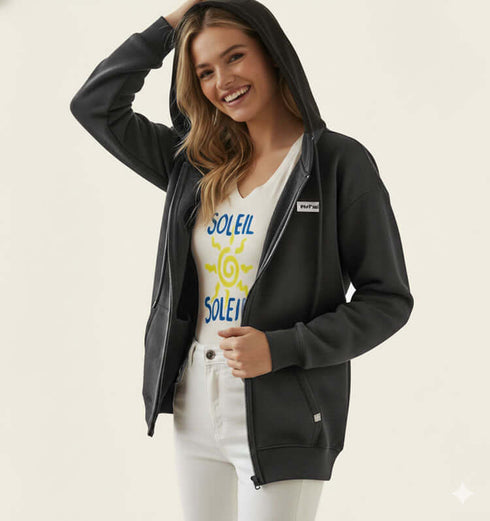 קרדיגן פוטר חתיכי ומפנק בגוון שחור, עם כיסים וכובע, עונדת טי שירט עם כיתוב צבעוני.