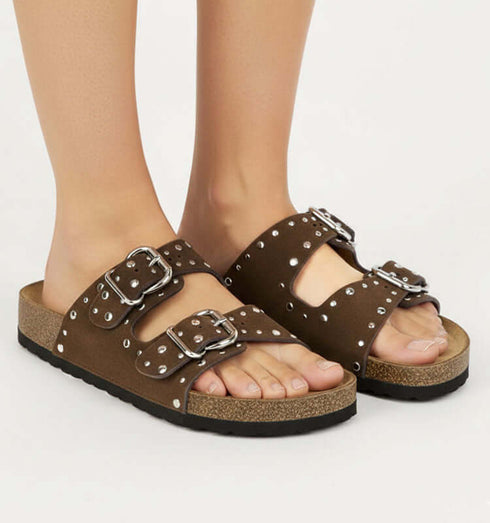 כפכף רצועות עם אבזמים וניטים כסופים בגוון חום, מתאים לסגנון יומיומי ונוח.