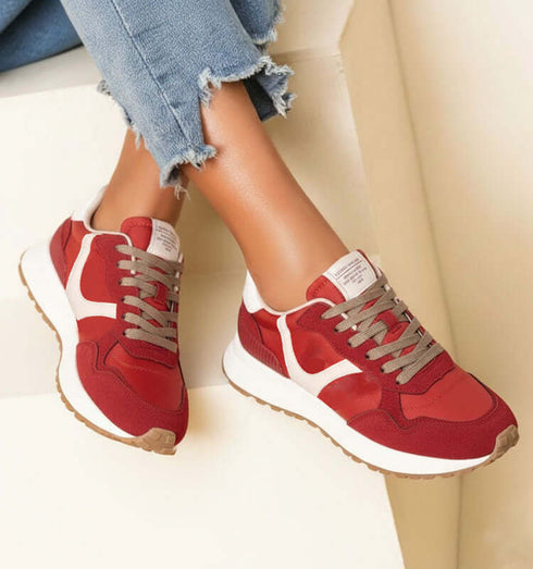 סניקרס ריצה קורינה בגווני אדום ולבן עם סוליה לבנה ותחתית חומה.