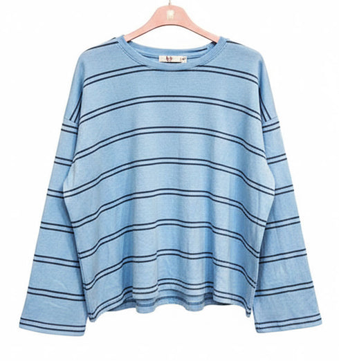 חולצת פסים תכלת עם שרוולים ארוכים, סגנון קז’ואל ונינוח.