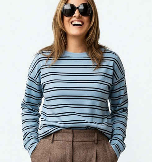 חולצת פסים תכלת עם שרוולים ארוכים, סגנון קז’ואל ונינוח.