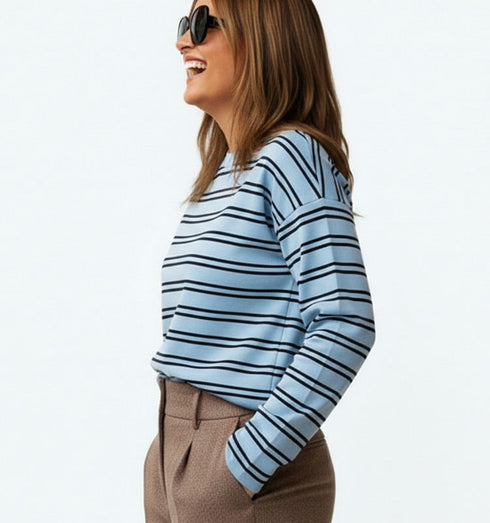 חולצת פסים תכלת עם שרוולים ארוכים, סגנון קז’ואל ונינוח.