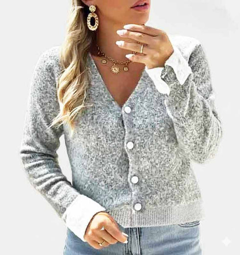 קרדיגן סריג קצר בגוון אפור עדין עם תוספת לבנה אלגנטית בשולי השרוולים.