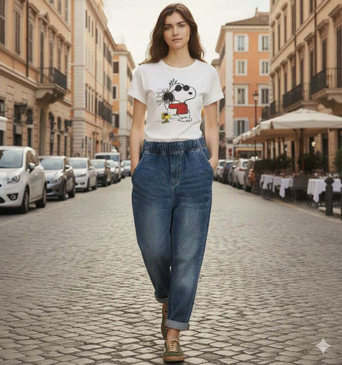 אישה בג'ינס ווינטג' מובחר בגזרה גבוהה עם כיסים צדדיים, צועדת ברחוב בעיר אירופאית.