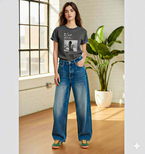 צעירה לובשת ג'ינס משופשף בגזרת בויפרנד גבוהה, אופנתי עם חולצה כהה ורקע צבעוני.