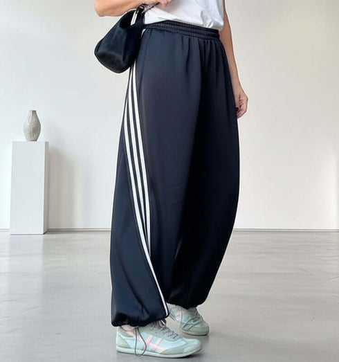 מיכנס מיקרופייבר רחב בגוון שחור עם פסים לבנים, כיסים וגומי במותניים.