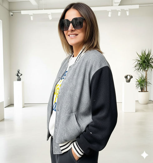 ג'קט ספורטיבי מבד טטויד אפור עם שרוולים שחורם, צווארון פסים וכיסים.