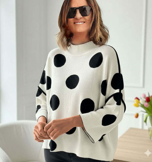 סריג לבן טרנדי מנוקד בשחור עם שרוולים יחודיים, מתאים לשילובים יומיומיים ושיקיים.