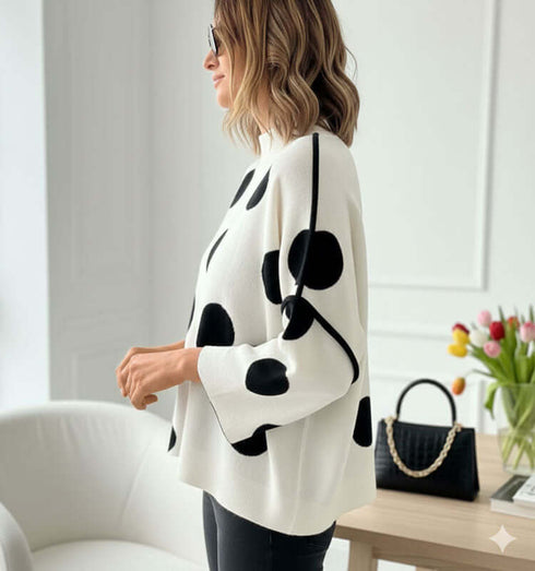 סריג לבן טרנדי מנוקד בשחור עם שרוולים יחודיים על דוגמנית בסגנון יומיומי.