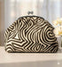 קלאץ' עור ז'אמש עם דוגמת זברה בצבעים שחור ולבן, בעל סגר מתכתי ומראה יוקרתי.