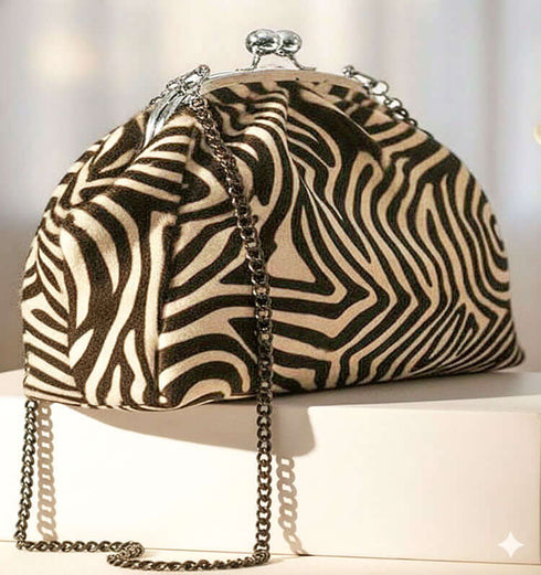 קלאץ' עור ז'אמש בגוון זברה עם סגר מתכת ורצועה מתכתית, תוספת שיק לאירועים חגיגיים.