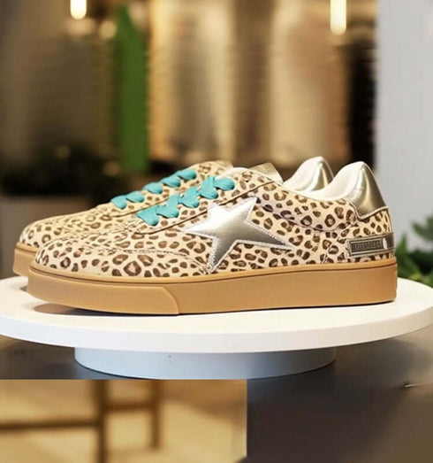 סניקרס מנומרות עם דפוס נועז, כוכב מוזהב ושרוכים בגוון טורקיז על פלטפורמה מעוצבת.