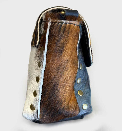 תיק צד מעורות פרווה עם דוגמאות צבעוניות ורצועת עור שחורה, עיצוב יוקרתי ונוח.