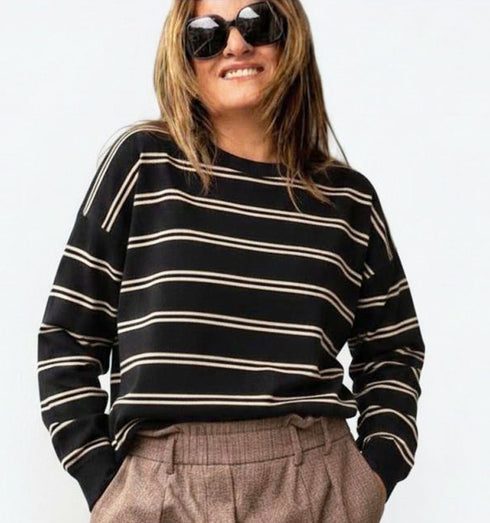 חולצת פסים שחורה עם שרוולים ארוכים, סגנון קז’ואל ונינוח.