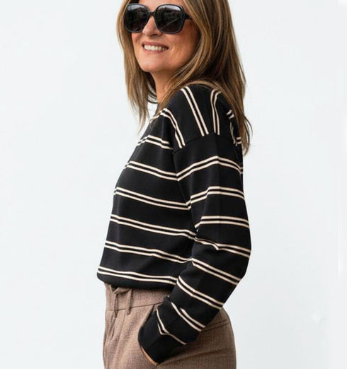 חולצת פסים שחורה עם שרוולים ארוכים, סגנון קז’ואל ונינוח.