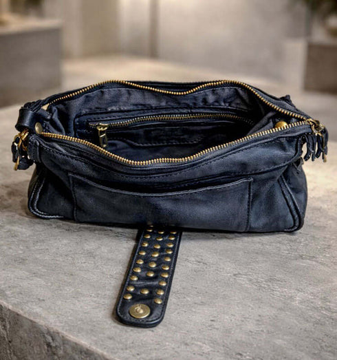 תיק עור פנימי שחור קלאסי עם סגירה עם רוכסן, רצועה עם ניטים נחושתיים, עבור שימוש יומיומי.