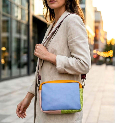 תיק צד מעור נפה בגווני תכלת, כתום וירוק, רצועת כתף סגולה, עיצוב יוקרתי ונוח.