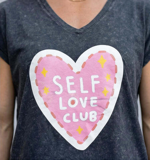 טישרט כותנה עם הדפס לב ורוד וכתוב SELF LOVE CLUB על רקע אפור.