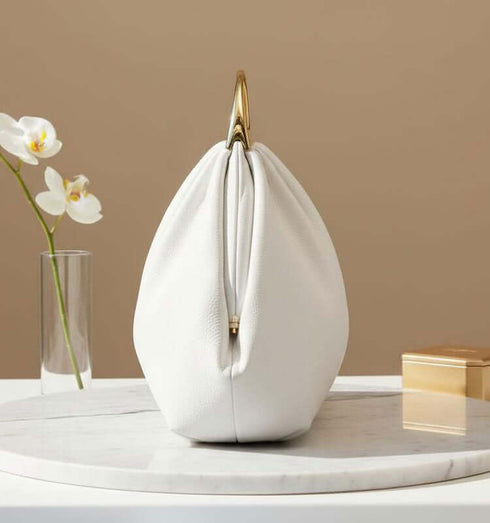 תיק ייחודי מעור איטלקי, לבן עם ידיות מוזהבות, מושלם לכל הופעה ואירוע.