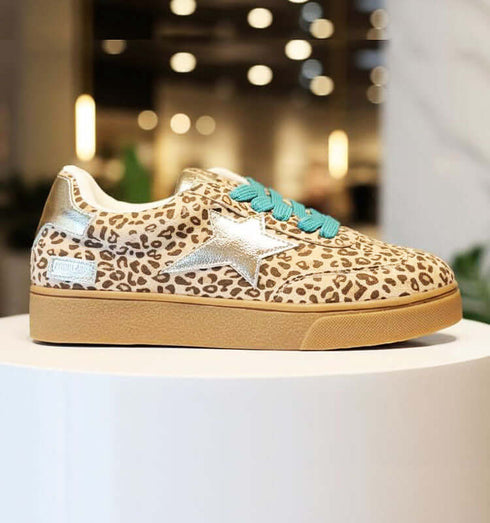 סניקרס מנומרות עם דפוס נועז, כוכב מוזהב ושרוכים טורקיז על פלטפורמה בגוון טבעי.