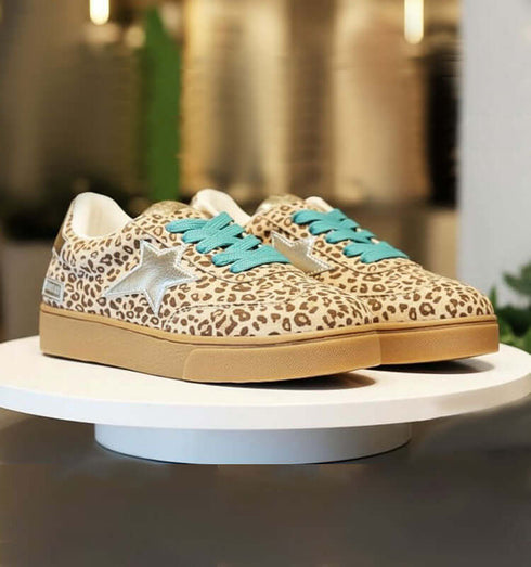 סניקרס מנומרות עם כוכב מוזהב ושרוכים טורקיז על פלטפורמה לבנה