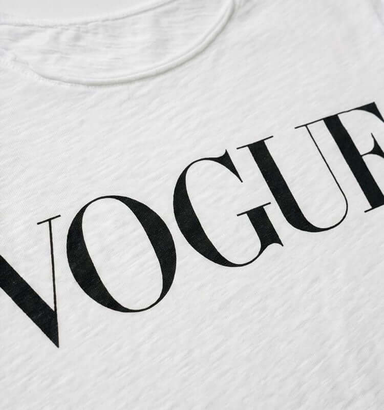 טישרט כותנה קלילה לבנה עם הדפס VOGUE מרשים על בד רך ונעים.